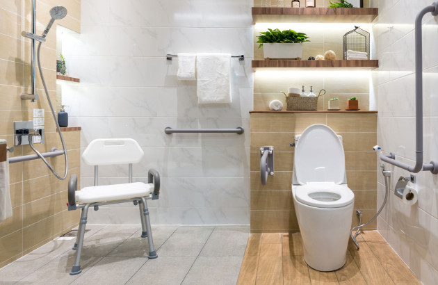 Toilettes adaptées aux personnes à mobilité réduite avec carrelage antidérapant avec barres de soutien et siège de douche sécurisé
