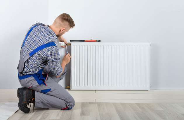 Artisan effectuant l'entretien d'un radiateur