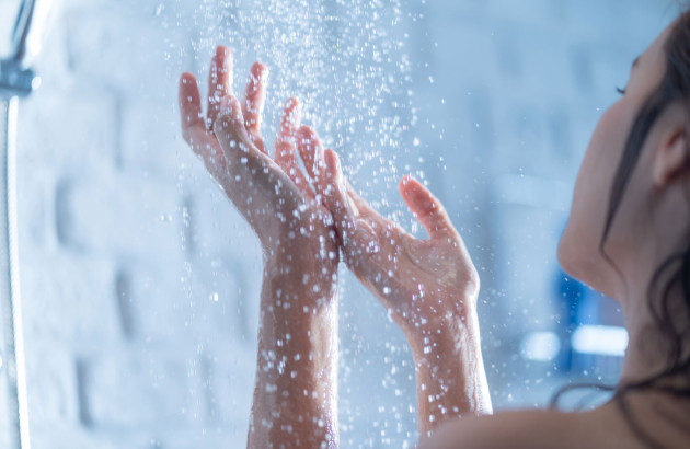 Femme qui apprécie l'eau qui coule de la douche