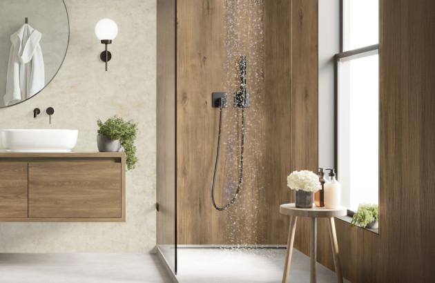Salle de bains avec une douche recouverte de panneaux muraux aspect bois, l'eau coule