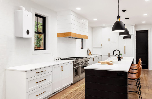 Chaudière murale blanche installée dans une cuisine moderne avec îlot central.