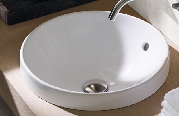 Vasque ronde en céramique blanche encastrée sur un meuble de salle de bains