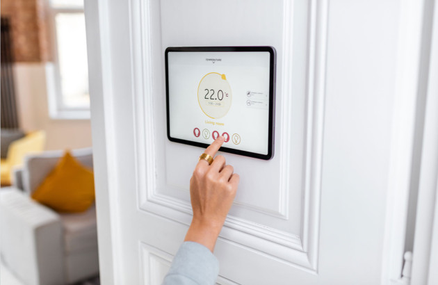 Interface domotique murale affichant la température intérieure et permettant le réglage du confort thermique dans le salon