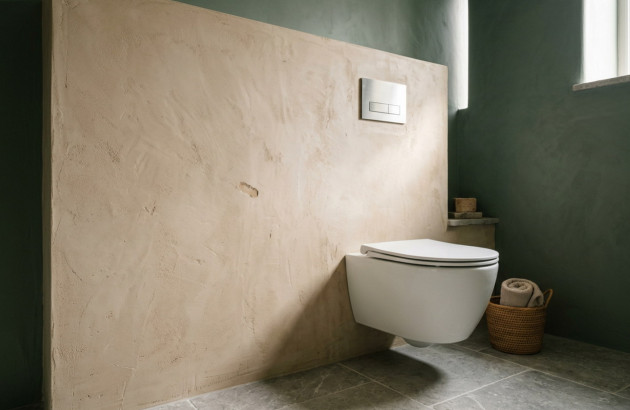 WC lavant suspendu dans une salle de bains moderne aux murs vert foncé et beige.