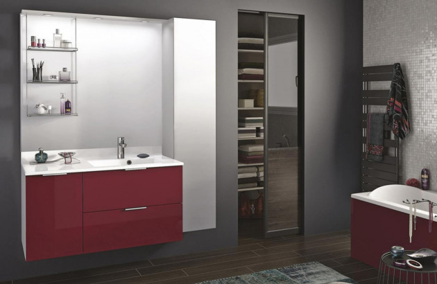 Salle de bains intégrant le rouge dans sa décoration avec un meuble et une baignoire rouge