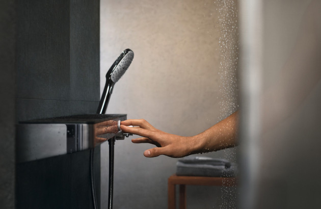 Personne poussant un bouton de mitigeur douche