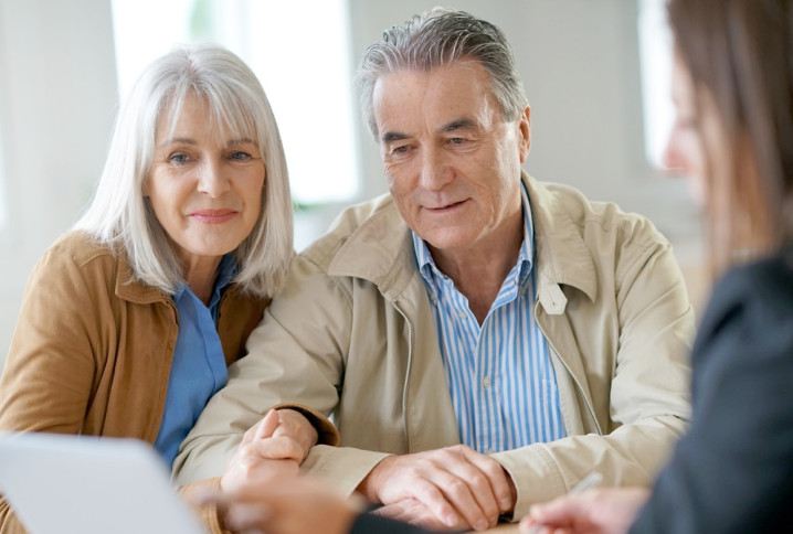 couple de retraité autour d'un ordinateur avec une conseillère