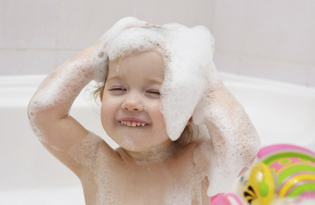 Enfant se lavant les cheveux dans baignoire