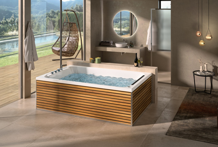 Baignoire balnéo habillée de bois dans une salle de bains avec vue sur jardin.