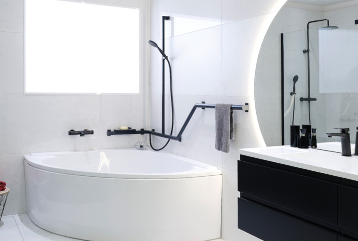 Salle de bains moderne avec baignoire d’angle, robinetterie noire