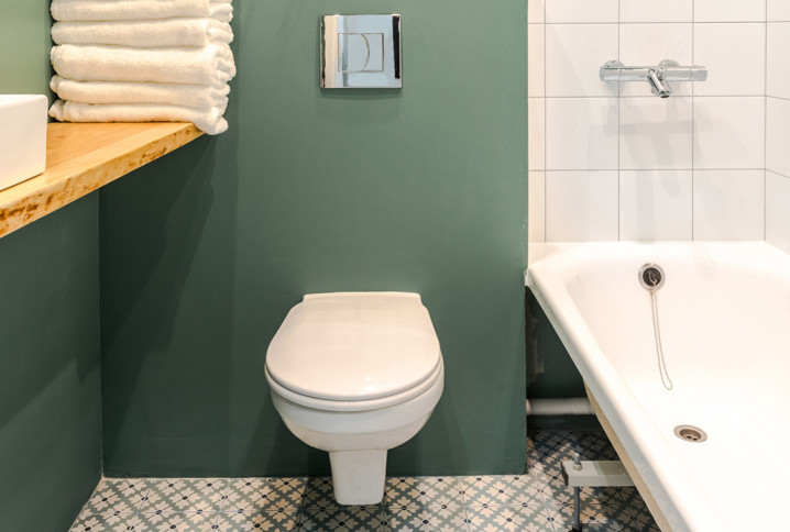 Petite salle de bains verte avec baignoire et WC