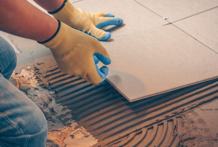 Homme qui pose des carreaux de carrelage extra fins