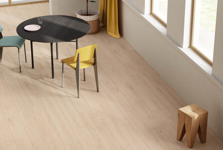 Carrelage imitation bois blanchi dans un salon lumineux avec table et chaises modernes, ambiance scandinave