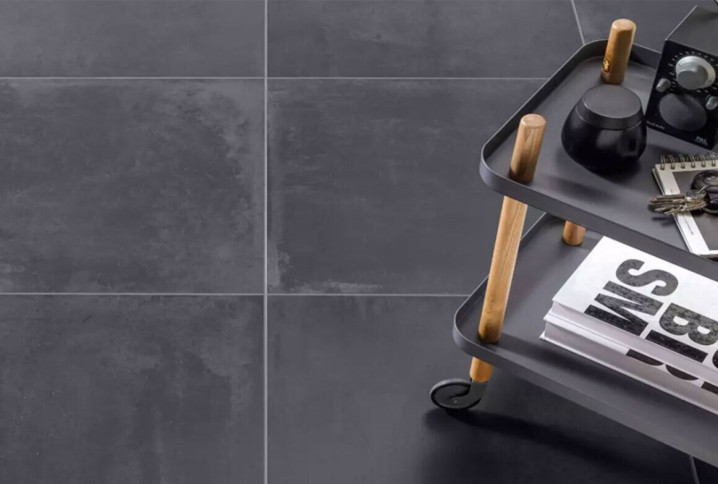 Carrelage noir grand format dans une cuisine contemporaine, finition mate effet béton, illustrant une tendance durable et élégante pour les cuisines en 2026.