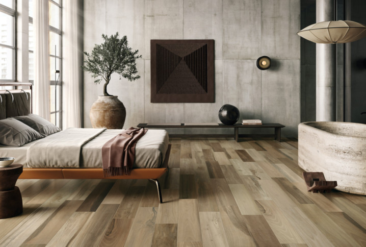 Chambre parentale avec sol imitation bois et baignoire îlot, ambiance loft contemporaine.