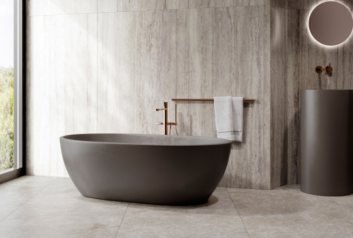 Salle de bains moderne avec baignoire îlot et carrelage travertin gris, pour une ambiance naturelle et contemporaine.