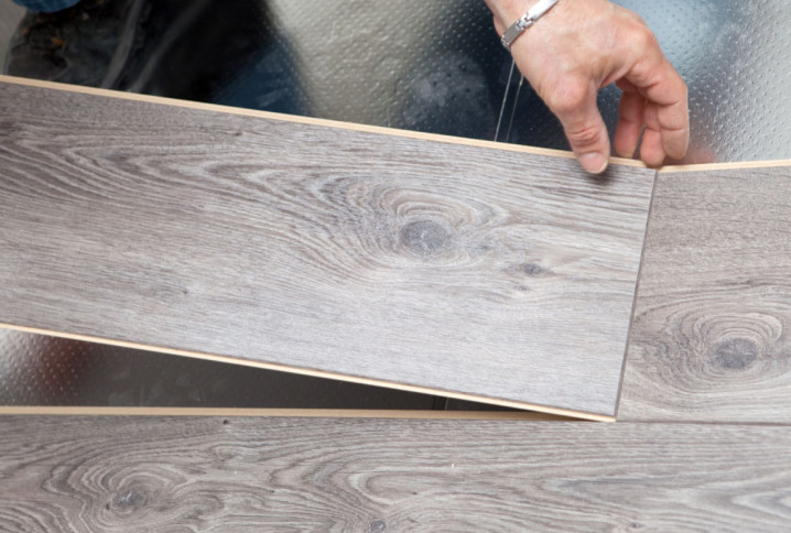 Professionnel qui installe un parquet gris clair