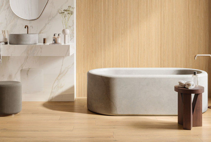 Salle de bains avec une baignoire, du carrelage mural et du parquet