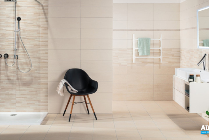 Salle de bains beige avec frise décorative.
