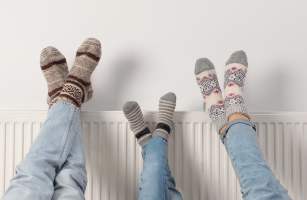 Personnes qui réchauffent leurs pieds avec un radiateur