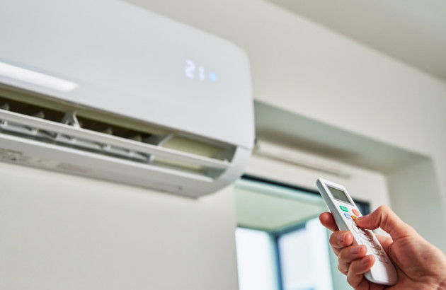 Personne qui utilise une climatisation avec une télécommande