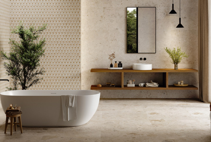 Salle de bains naturelle avec baignoire îlot blanche, vasque à poser et carrelage mural décoratif en relief.