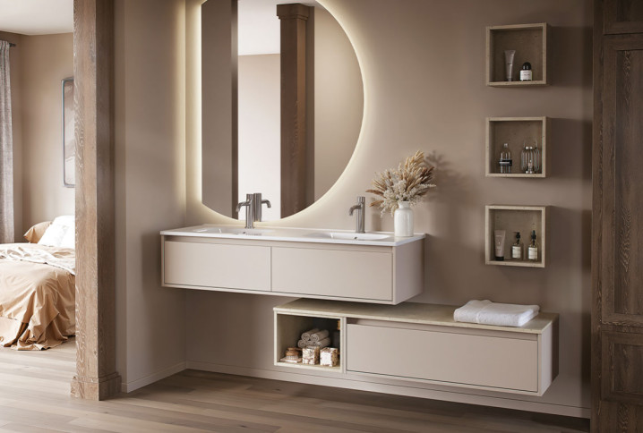 Meuble double vasque suspendu avec miroir rond rétroéclairé dans une salle de bains aux tons beige et bois.