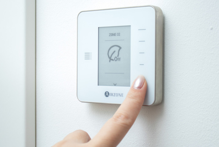 Femme qui utilise un thermostat d'ambiance