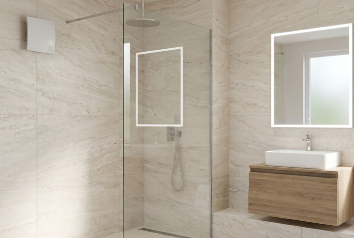 Salle de bains moderne avec extracteur mural VMC installé près de la douche pour évacuer l’humidité.