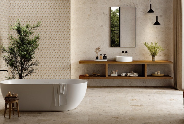 Salle de bains zen avec baignoire îlot, meuble suspendu en bois et carrelage texturé aux tons beiges naturels.
