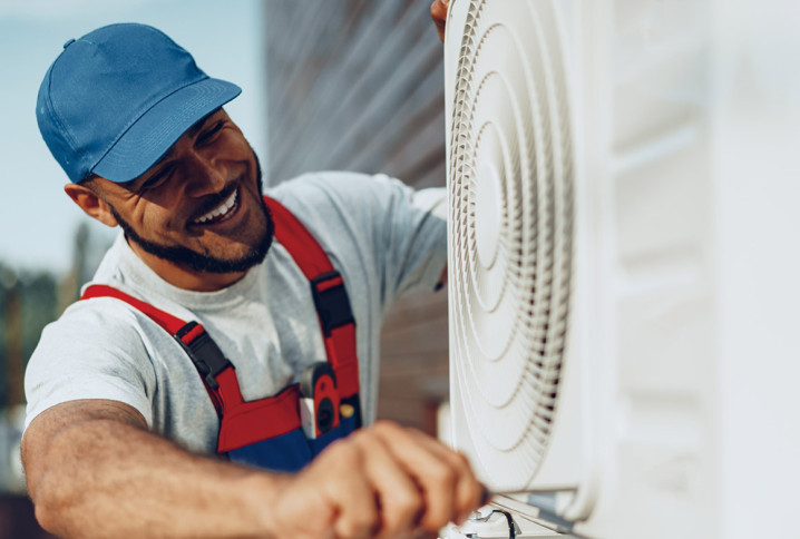 Technicien réalisant la mise en service d’une unité extérieure de climatisation