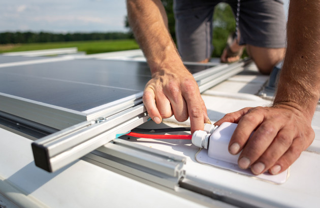 Homme qui installe des câbles de panneau solaire