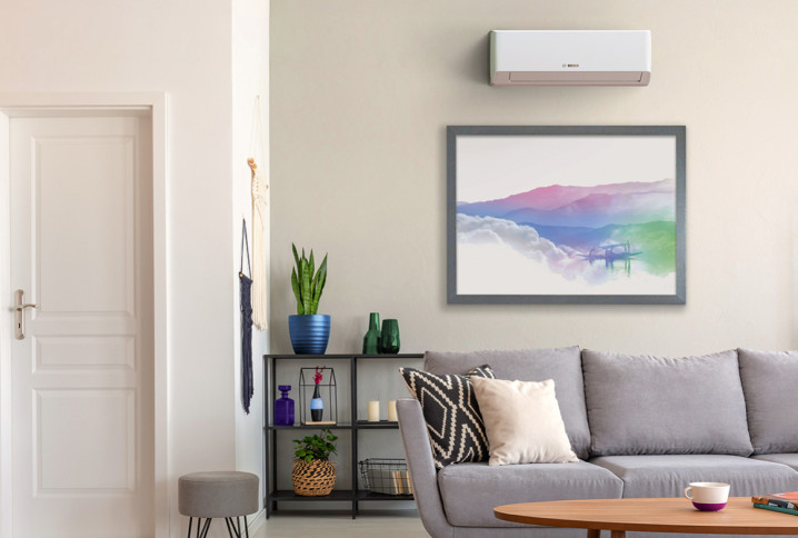 Salon moderne avec climatisation murale installée au-dessus du canapé pour un confort thermique optimal.