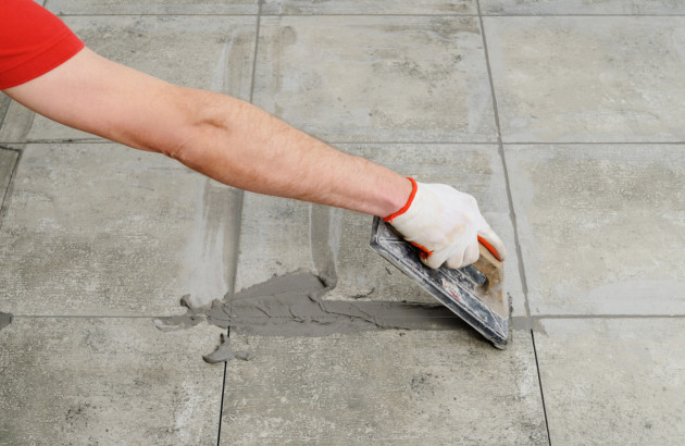 Personne qui fait ses joints de carrelage