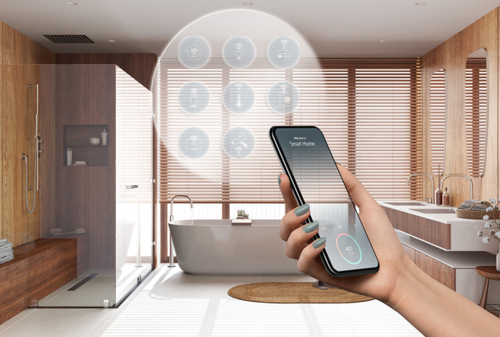 Femme qui tient son téléphone avec un affichage d'options pour sa salle de bains connectée