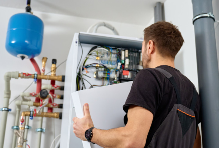 Technicien intervenant sur une pompe à chaleur avec fluide R290, installation chauffage domestique économe et performante