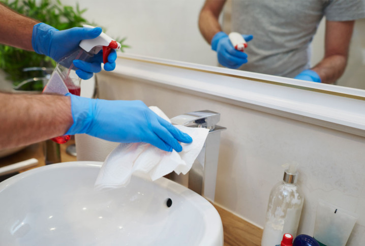 Nettoyage minutieux d’un robinet de salle de bains avec produit désinfectant et chiffon.
