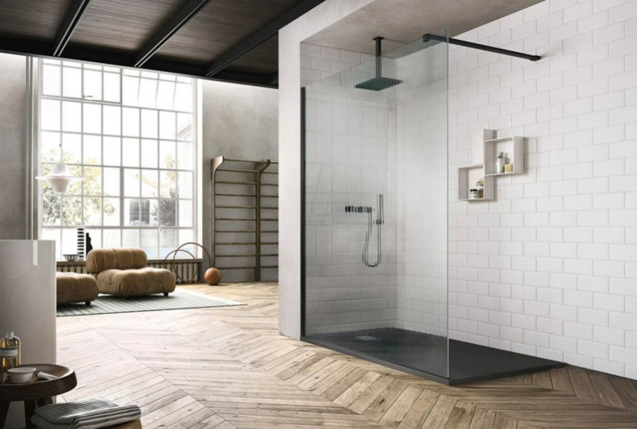 salle de bain moderne et spacieuse avec une grande douche à l'italienne à paroi en verre strié avec un mur en carrelage et un sol en parquet