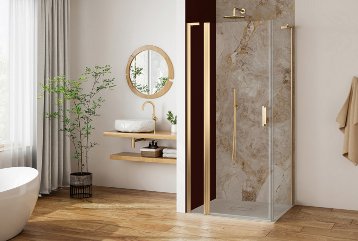 Salle de bains lumineuse avec receveur de douche compact, paroi vitrée et finitions dorées.