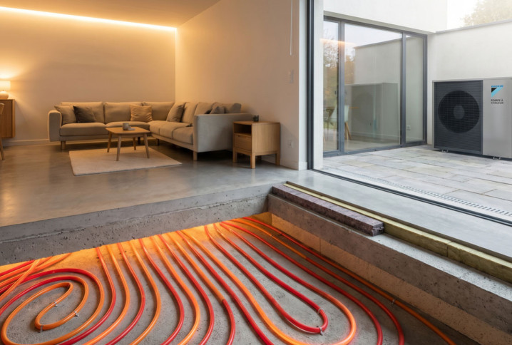 Pompe à chaleur reliée à un plancher chauffant dans une maison moderne avec vue sur l’installation au sol.