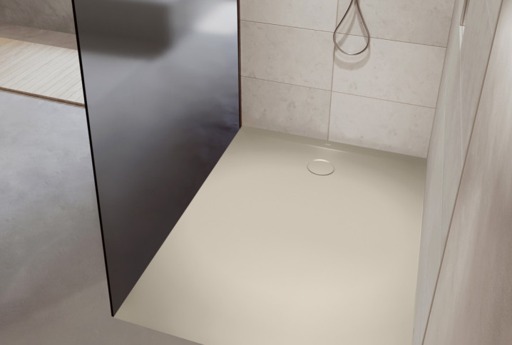 Receveur de douche extra-plat beige avec bonde centrale dans une douche moderne