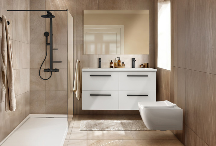 Salle de bains moderne avec douche à l’italienne, meuble double vasque suspendu et carrelage beige effet pierre.