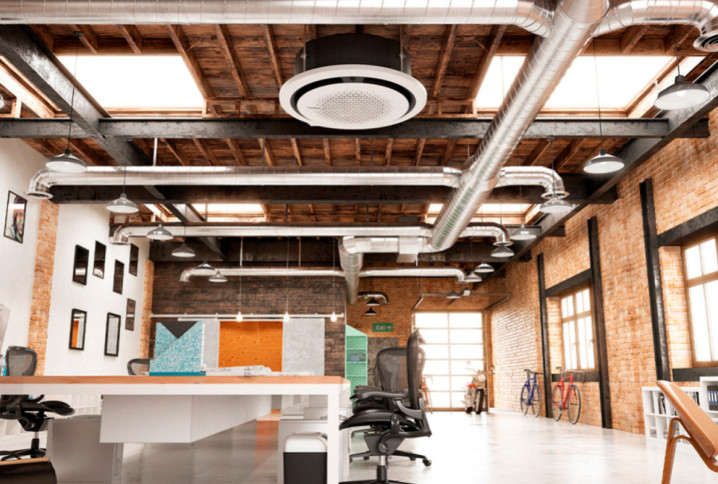 Open space industriel équipé d’un système de climatisation et de ventilation au plafond.