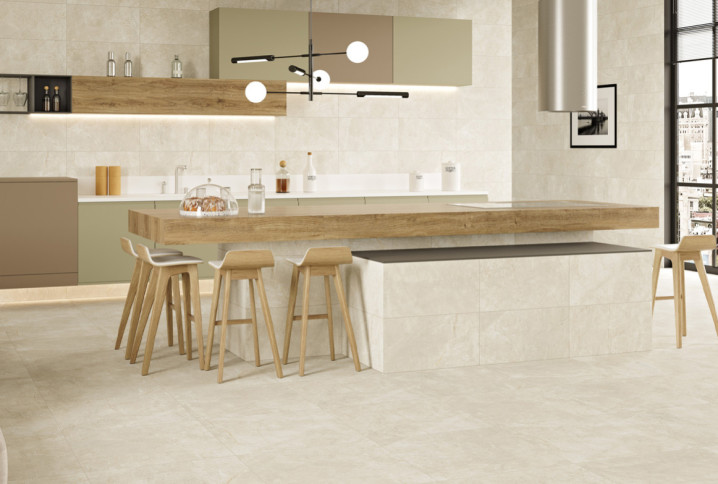Cuisine moderne avec îlot central en bois et carrelage grand format effet pierre beige.