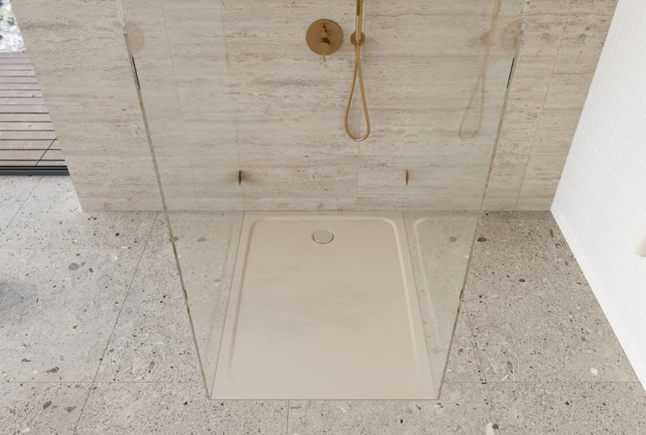 Receveur de douche extra-plat beige intégré dans une douche contemporaine avec parois vitrées et revêtements effet pierre.