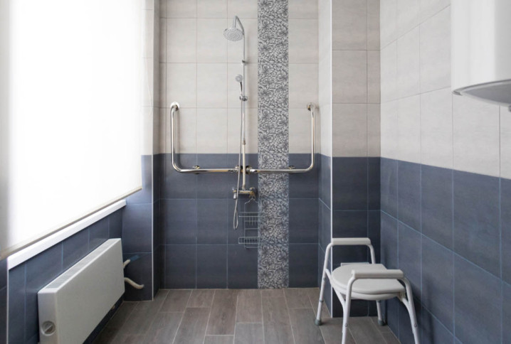 Salle de bains sécurisée avec douche senior équipée de barres d’appui et siège, idéale pour remplacer une baignoire.