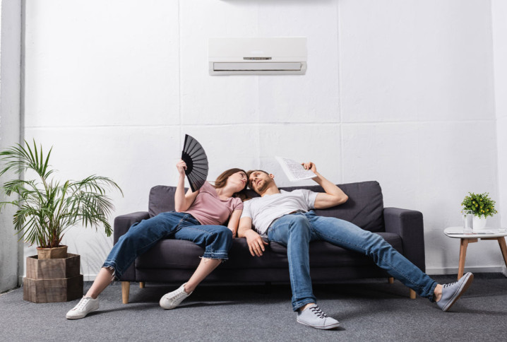 Couple qui a chaud mais qui profite de l'air frais de leur climatisation