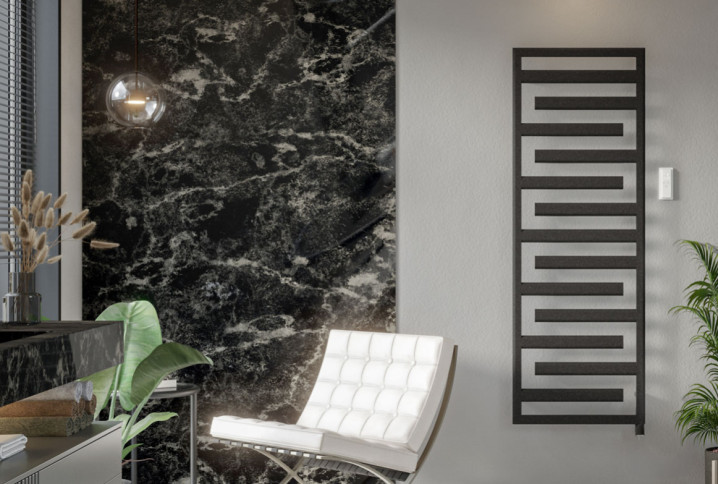 Sèche-serviettes design noir intégré dans une salle de bains contemporaine avec revêtement effet marbre noir et mobilier haut de gamme.