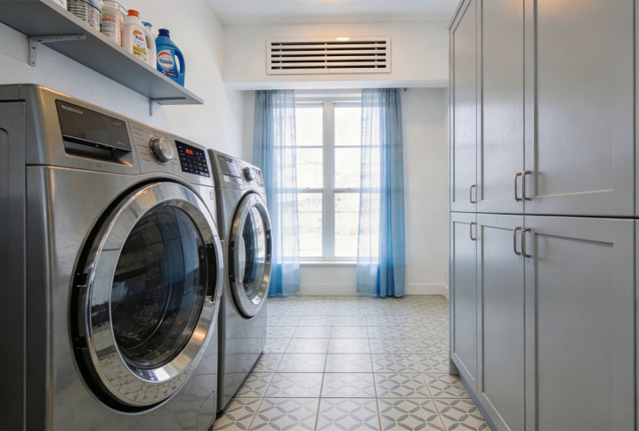 Buanderie avec lave-linge, sèche-linge et grille de ventilation