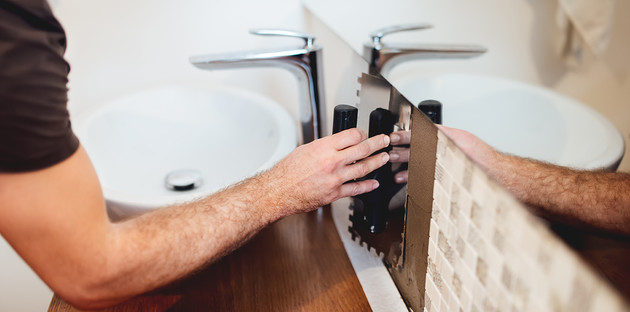 Artisan posant de la mosaïque dans une salle de bain